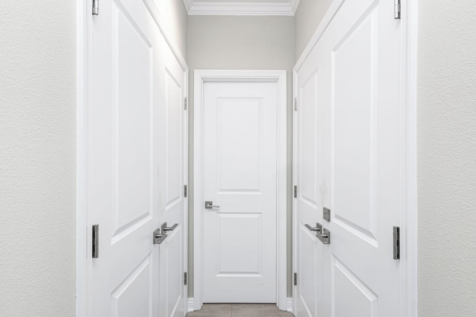 Clean hallway with elegant paneled doors and modern hardware creates a welcoming sense of privacy and order throughout your stay.