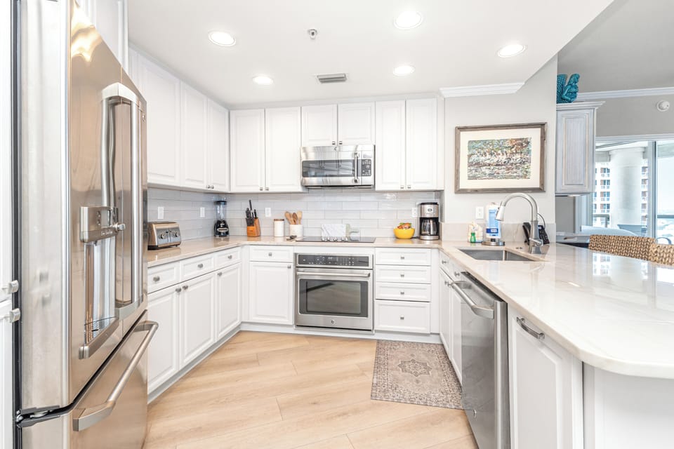 Step into your bright, fully equipped kitchen with gleaming countertops, modern appliances, and everything you need to whip up a home-cooked meal while on vacation.