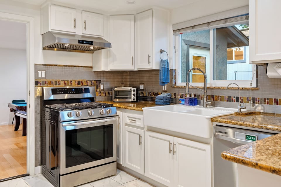 Kitchen - Large Farmhouse Sink with filtered water alongside a stainless steel gas cooktop