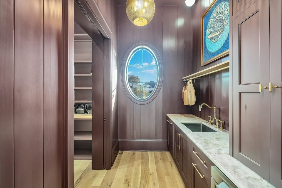 Your private butler's pantry offers marble counters and ocean views through the oval window, perfect for meal prep.