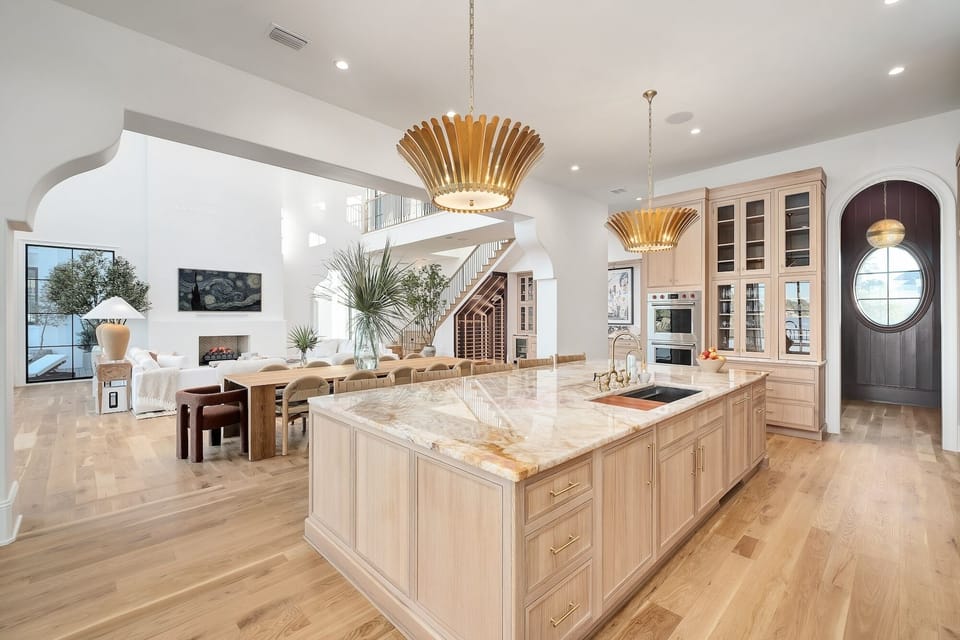 Your spacious kitchen flows seamlessly into the dining area, where marble countertops and warm wood tones create the perfect setting for memorable meals.