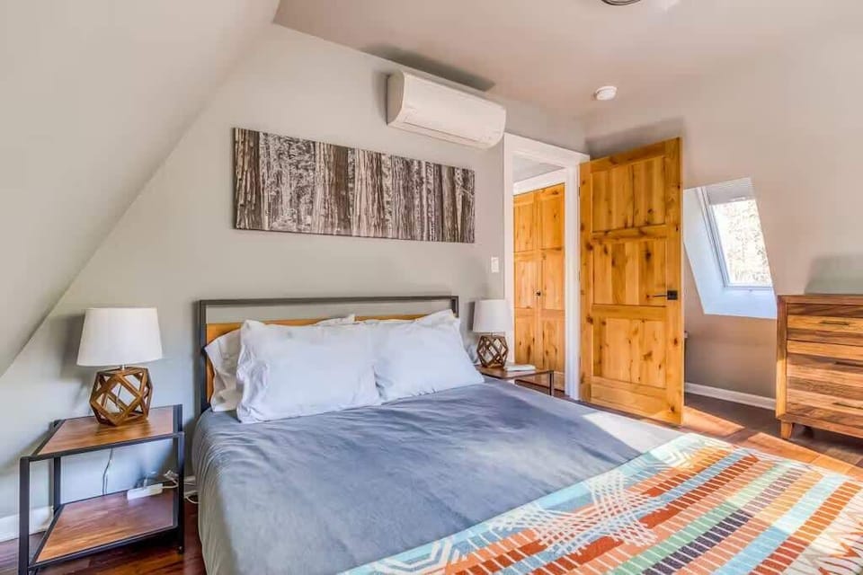 Relax in this bright, cozy bedroom with unique artwork and a comfy bed. Your perfect rest stop!