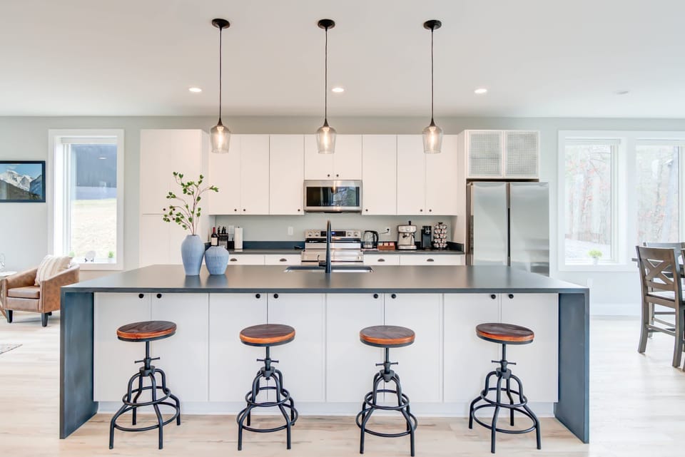 Enjoy meals or moments of relaxation at the kitchen island table, set in a bright space with stunning views of nature through the glass windows.