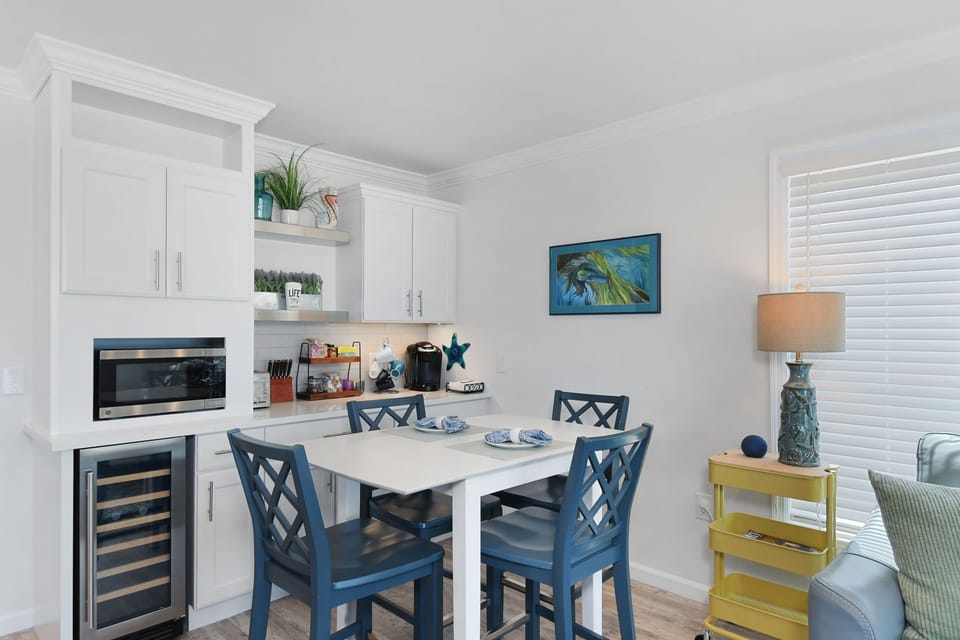 Bright dining area beside the coffee bar with extra cabinet storage and coastal 