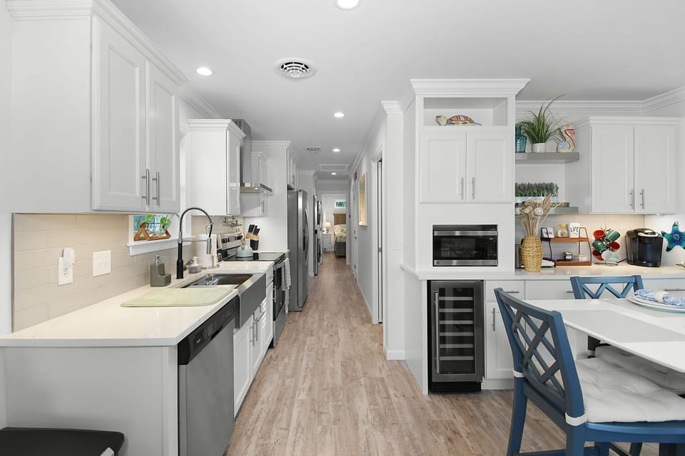 Bright and fully stocked kitchen with stainless steel appliances and coastal sty