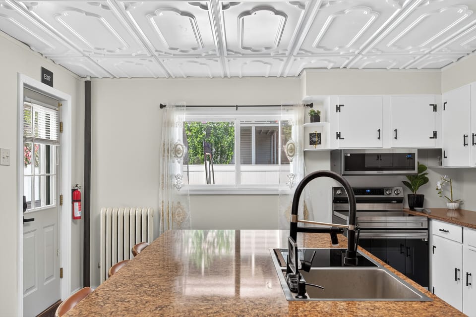 Modern kitchen with white cabinets, black hardware, and a spacious island.