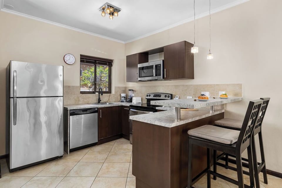 Calling all foodies! Our fully equipped kitchen features modern appliances and a convenient 2-seater island counter, perfect for whipping up delicious meals and enjoying morning coffee.