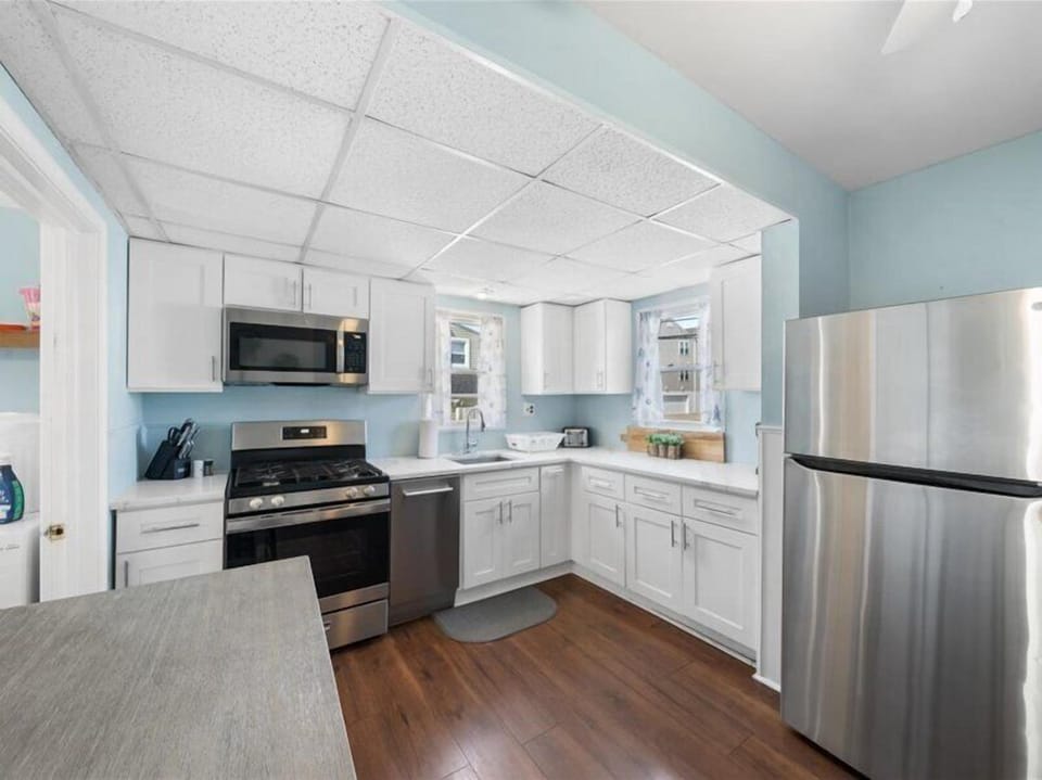 Cook, chat, and sip—this open kitchen blends coastal charm with stainless steel style.