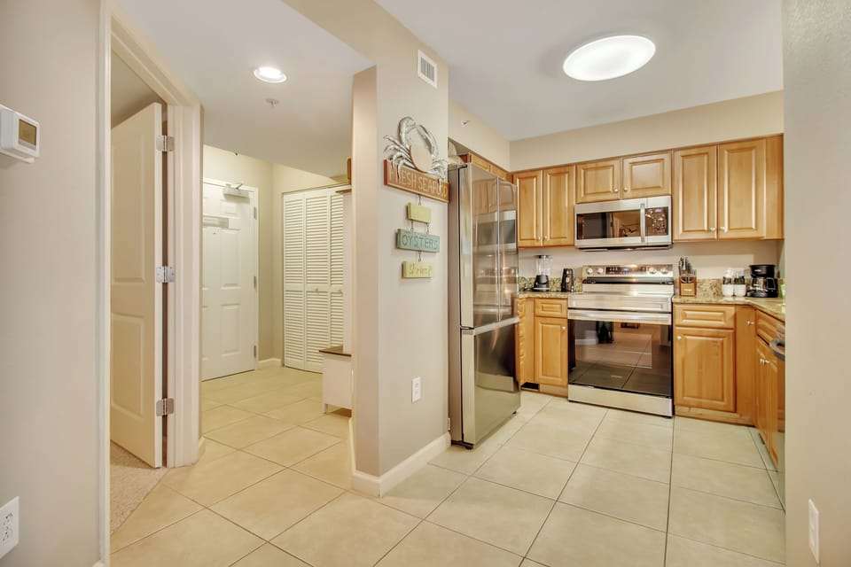 Your fully equipped kitchen awaits with warm wood cabinets, stainless steel appliances, and everything you need to create memorable meals.