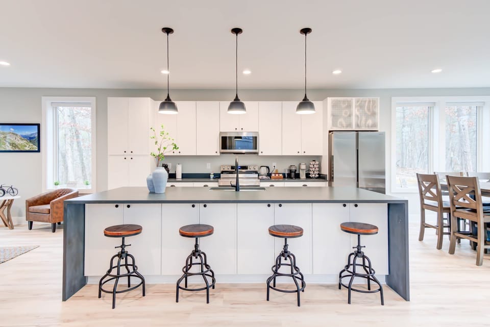 Enjoy meals or moments of relaxation at the kitchen island table, set in a bright space with stunning views of nature through the glass windows.
