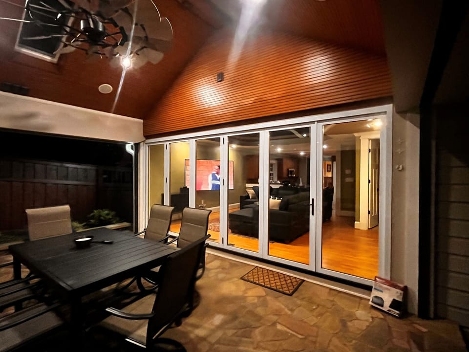 Backyard patio with dining table, vaulted ceiling with in-ceiling speakers