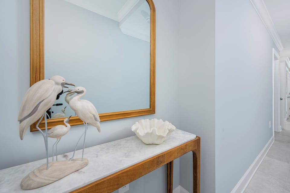 Admire the elegant entryway featuring decorative bird sculptures and a stylish bowl atop a marbled console table