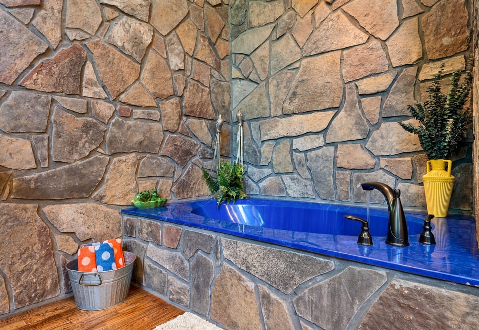 Relaxation is mandatory in this deep blue soaking tub set in a striking stone surround. It’s giving spa vibes in the woods.