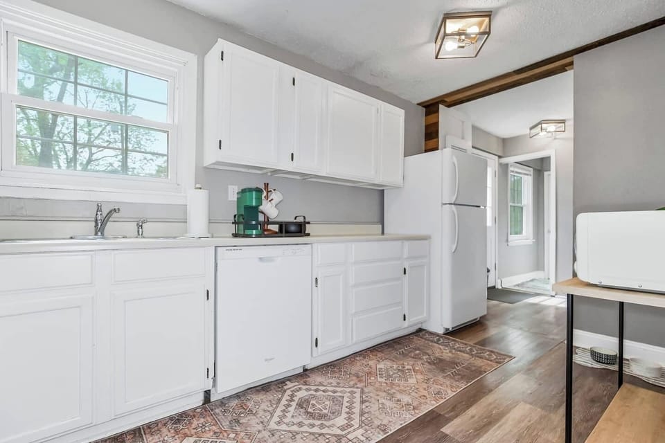 Double basin sink with large window facing fenced in backyard.