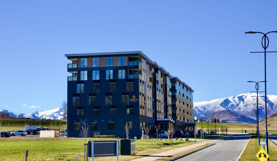 Modern building set against stunning alpine scenery—your Queenstown base!