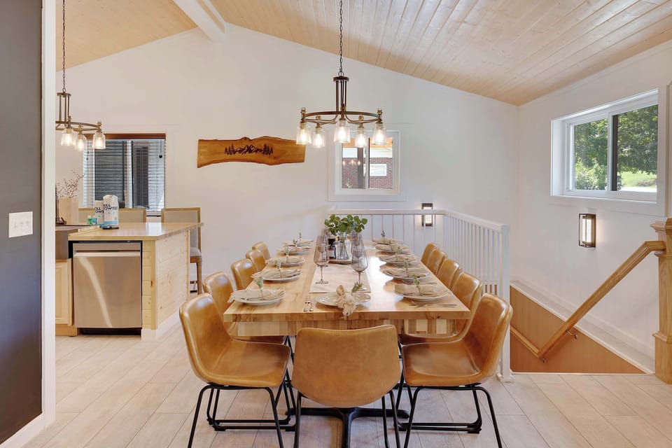 Modern dining area with a large wooden table and leather chairs for group meals.