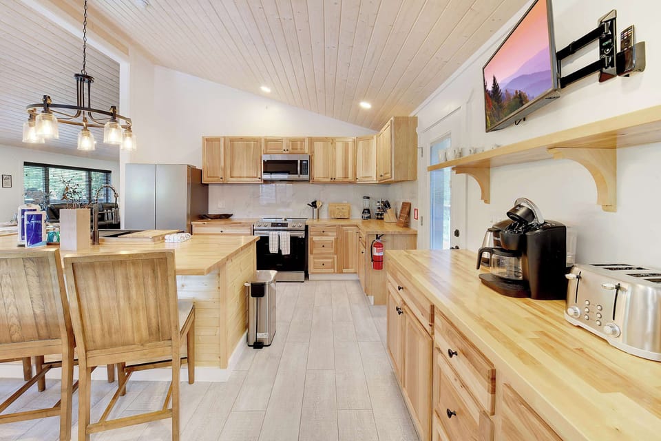 Modern kitchen with wooden cabinetry and a breakfast bar for casual dining.