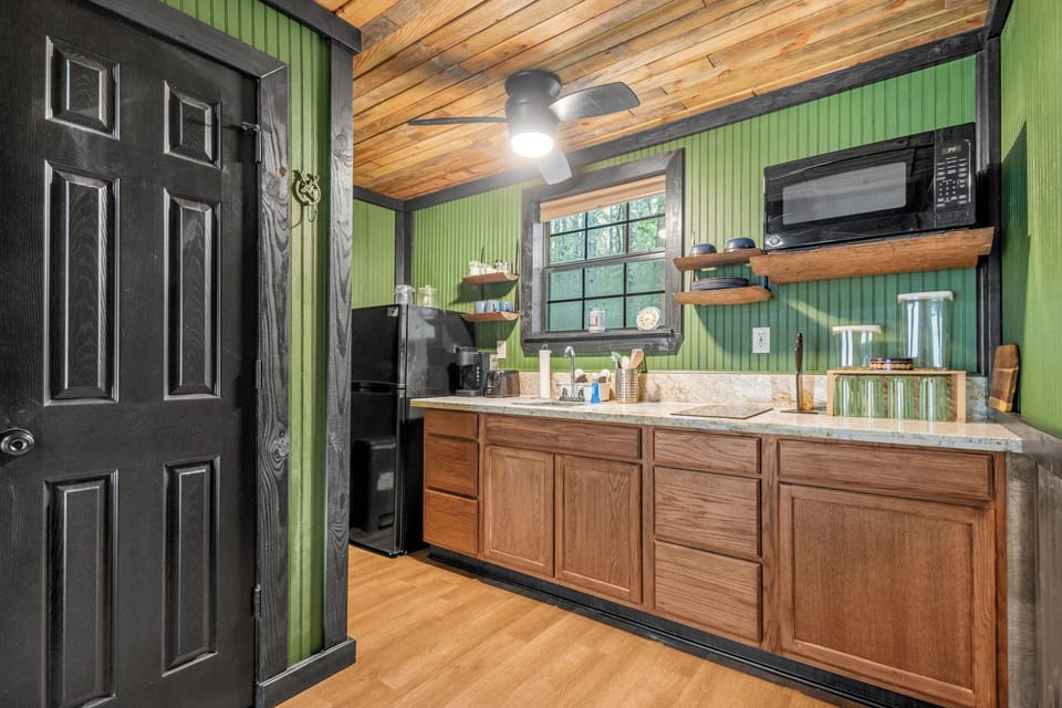 Kitchen has marble counters, 2 burner stove, microwave, fridge, toaster, Keurig and Ninja blender with your basic kitchen essentials.