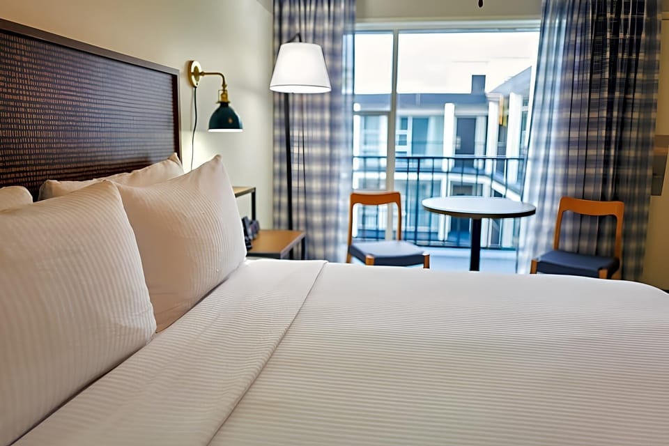 Wake up to soft light and balcony views beyond.