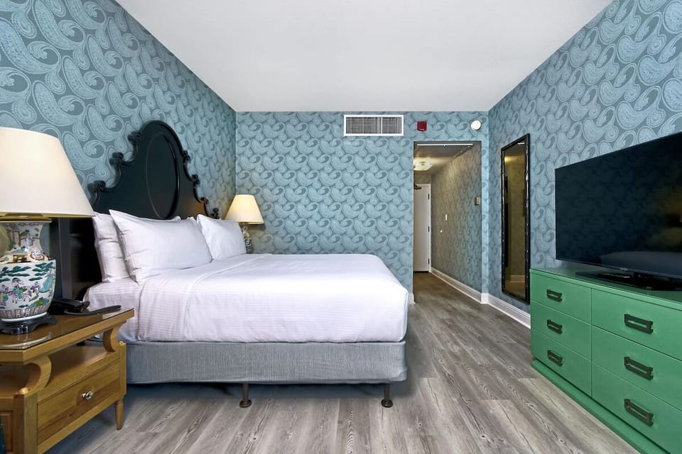 Unwind in crisp linens with statement headboard and TV.