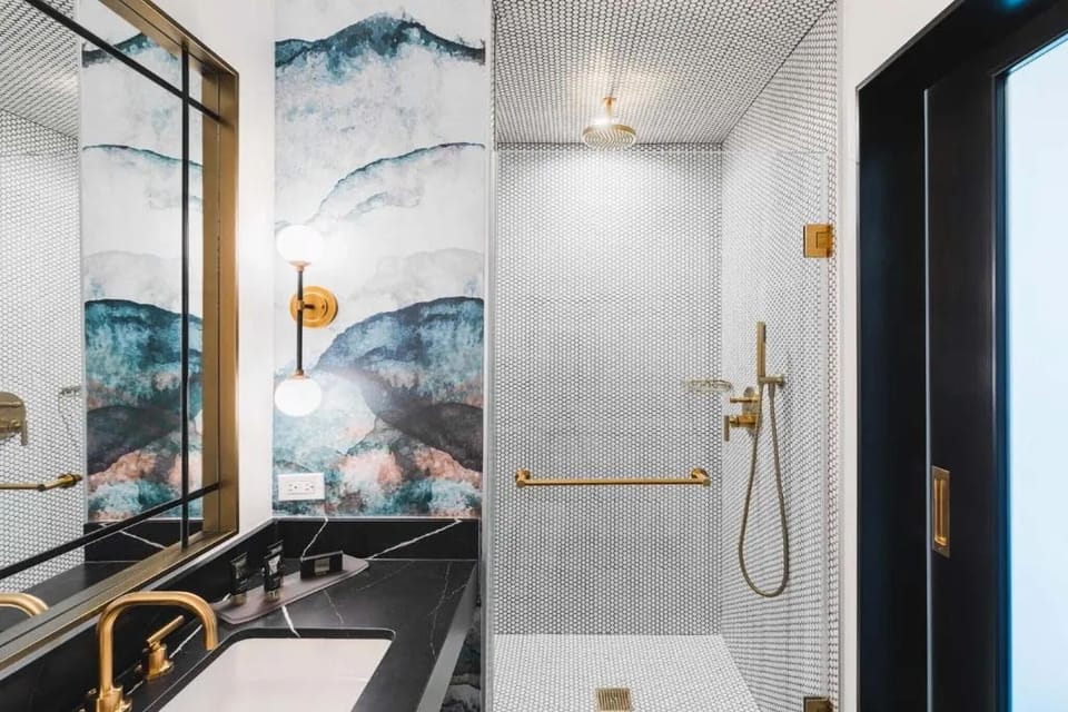 Rinse off in a spacious walk-in shower with chic brass accents.
