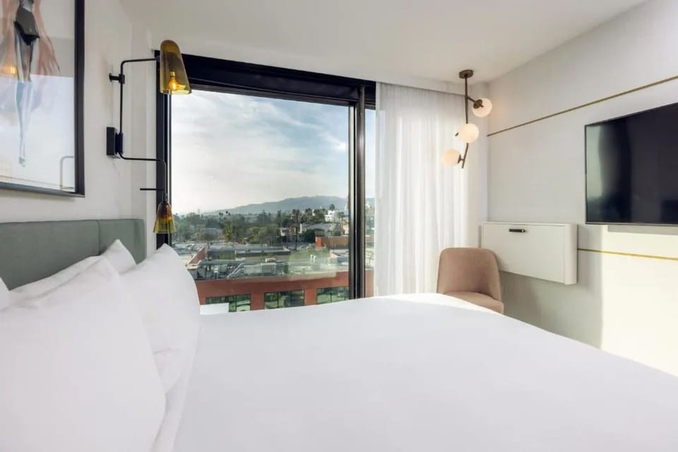 Soak in skyline views from bed with sunlight spilling in.