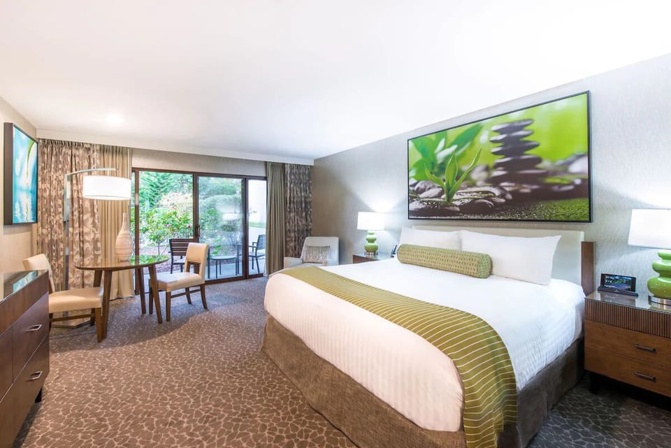 Unwind in a sunlit king room with garden-facing patio doors.