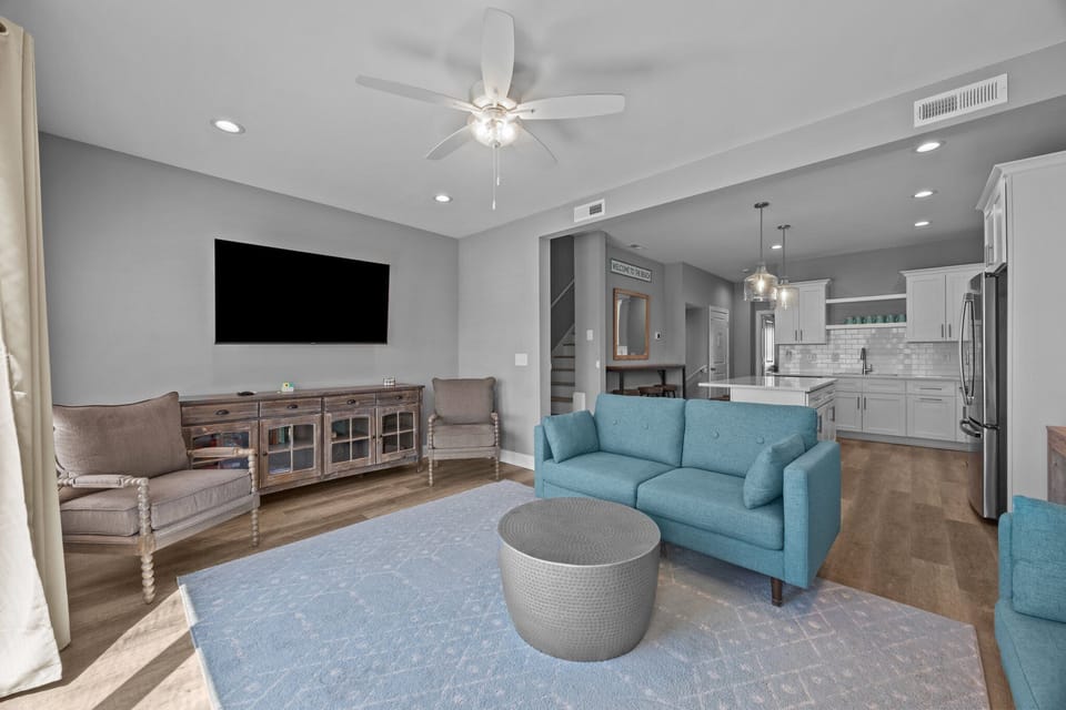 Living Room with 2 couches, end table, dresser and 65" smart TV.