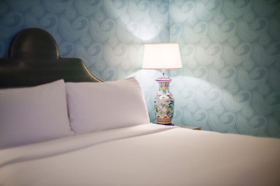 Drift off with soft bedside glow and serene patterned walls.