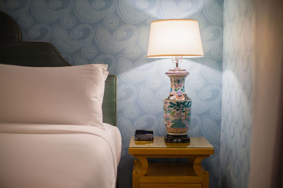Relax beside warm lighting and charming, artful bedside details.
