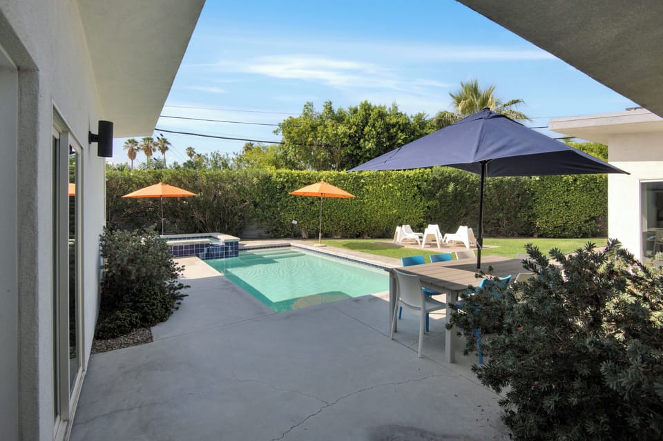 Covered patio overlooking pool and spa with outdoor dining area