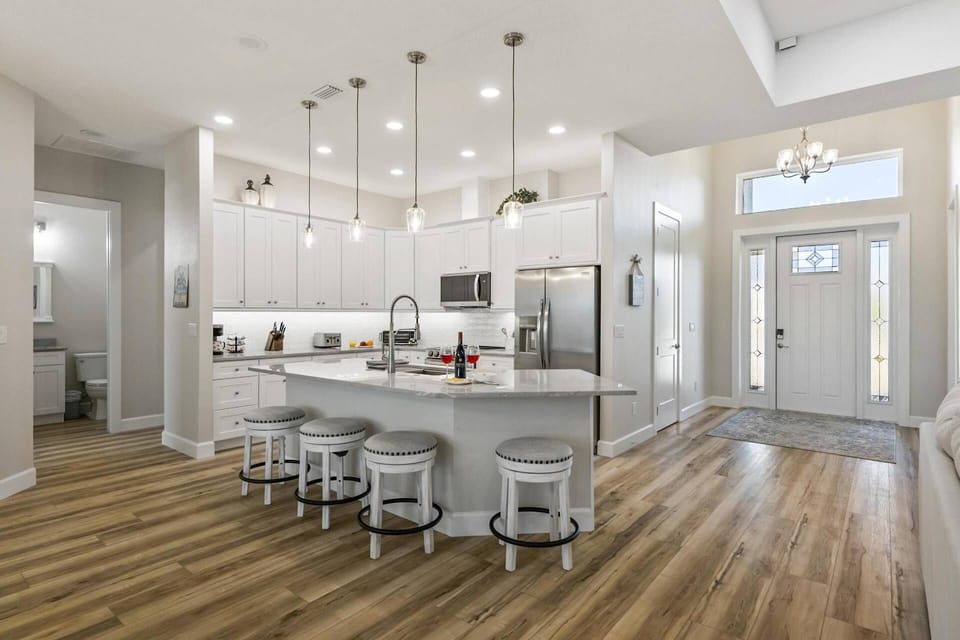 Bright and spacious kitchen featuring a large center island with bar seating, modern appliances, and ample counter space, perfect for gathering.