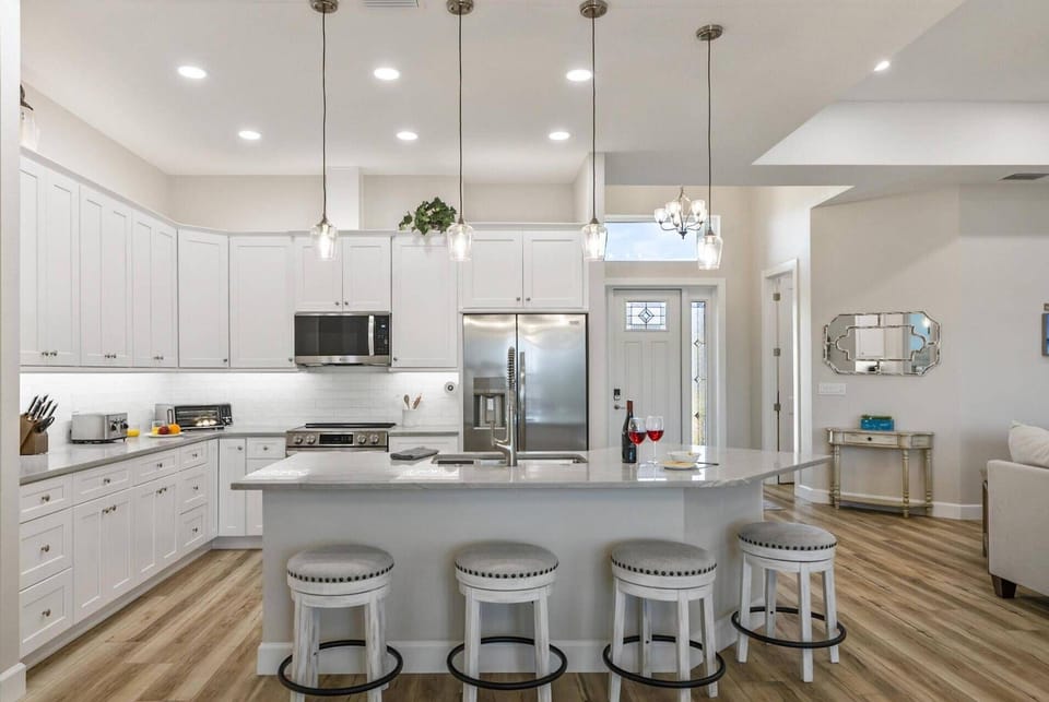 Bright and spacious kitchen featuring a large center island with bar seating, modern appliances, and ample counter space, perfect for gathering.