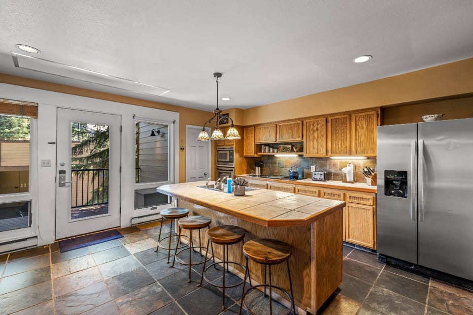 Down a level is the large kitchen space with barstools for additional entertaining space and back deck.