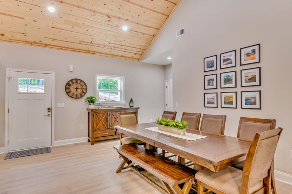Part of the open-concept great room, the dining area sits beneath vaulted cedar-plank ceilings, offering a warm, rustic charm. Gather around the large table for big family meals, shared stories, and memorable moments in the heart of the home.