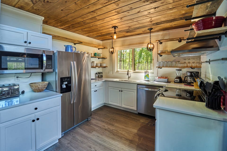 Cook in style with stainless steel appliances, open shelving, and warm wood finishes.