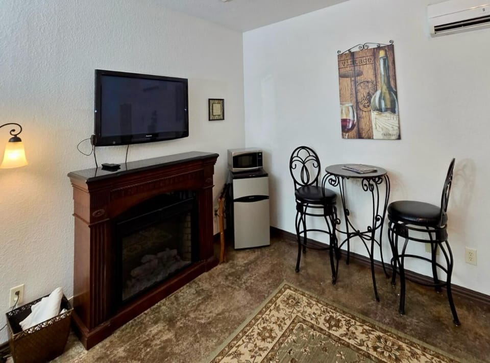 Charming Retreat: Relax by the fireplace with a TV, mini fridge, and stylish bistro seating!