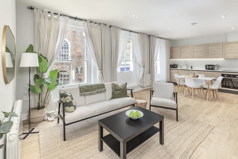 Open-plan living area featuring bright windows, comfortable seating, and a seamless flow into the kitchen, this is where you live, work, and unwind.