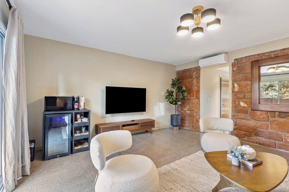 Exposed brick accent wall. Coffee maker, microwave, wine/mini fridge, smart tv.