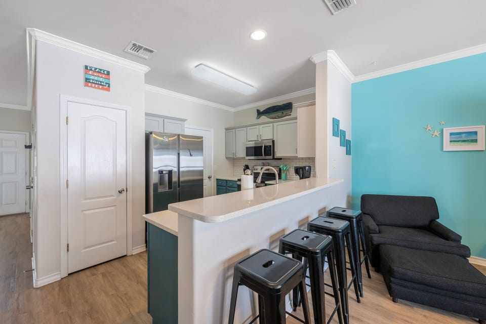 Your bright kitchen opens to a cozy living space where you can prepare meals and relax after beach days.