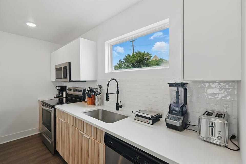 Sleek, modern, and functional, this kitchen is fully equipped with everything you need to whip up a good meal, including a coffee machine, kettle, blender, toaster, and panini press!