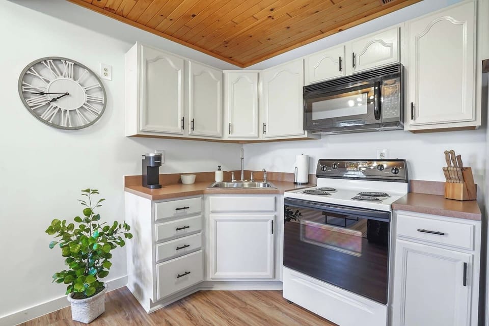 This bright kitchen has white cabinets, modern appliances, and warm wood touches. It’s a cozy, practical spot to make your morning coffee or cook up a meal after a day of exploring.