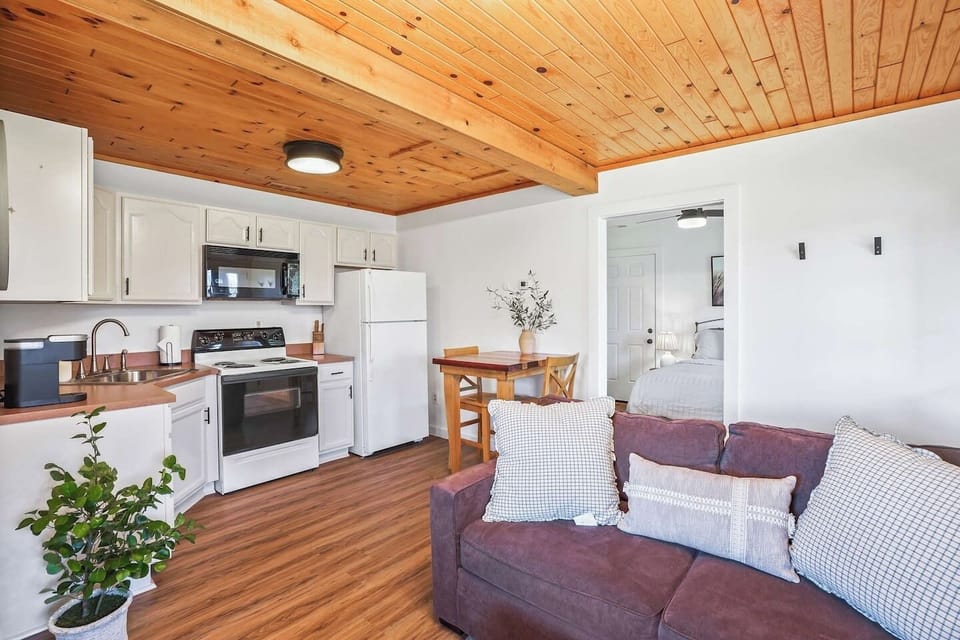This bright and cozy space has a comfy sofa, a warm wood ceiling, and a kitchen with everything you need plus a dining table. It’s the perfect place to cook, hang out, and enjoy time together.