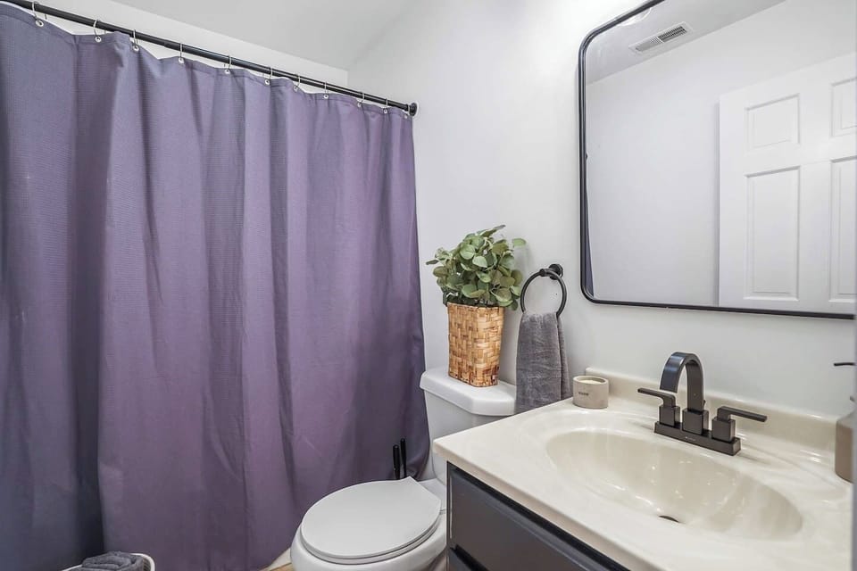 This bathroom has a clean vanity, modern fixtures, and a full shower with a curtain. Simple and bright, it’s a comfortable space to freshen up during your stay.