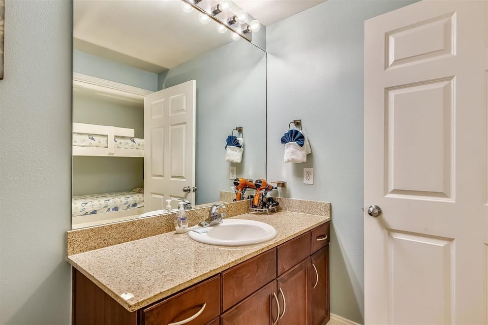 Bathroom adjacent to bunk area, shower / tub combo.