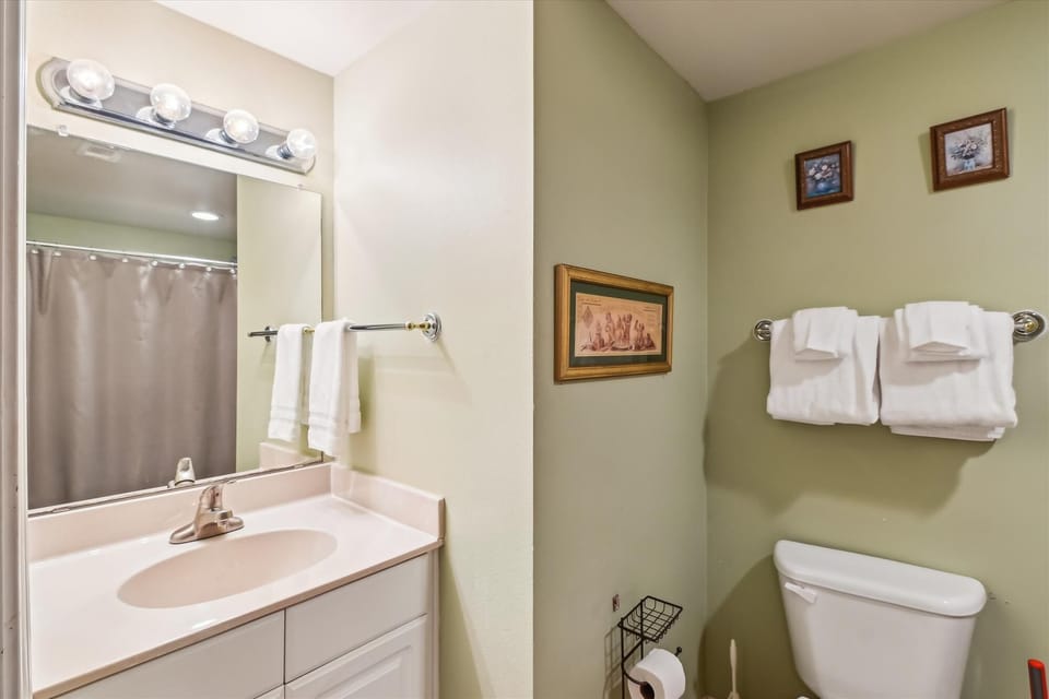 Bunk Room bathroom with tub shower combo, toilet and sink vanity