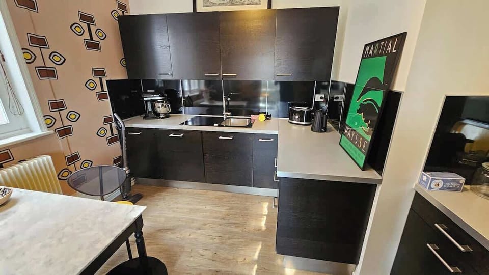 Cuisine équipée avec machine à café, bouilloire, grille-pain, micro-ondes, plaques de cuisson, four, lave vaisselle et réfrigérateur avec congélateur.
Coin repas pour trois personnes.