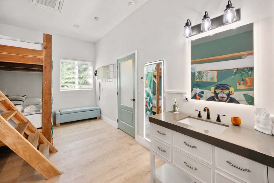 Surf-Themed Bunk Bedroom Featuring Twin Bunk Beds, Bold Wall Art, and Bright Design — Created for Youthful Energy, Comfort, and Shared Stays

