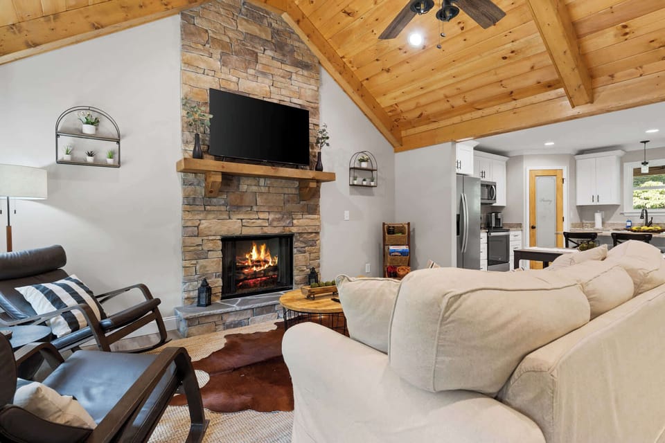 Welcome to our cozy living room, featuring plush seating, a 60" smart TV, and a warm indoor fireplace — your perfect spot to relax and unwind.