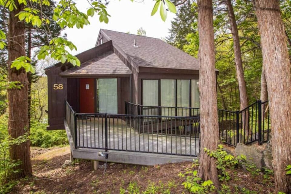 Discover the charming exterior of Treetop Villa 58, nestled perfectly amidst the trees with glimpses of the lake.